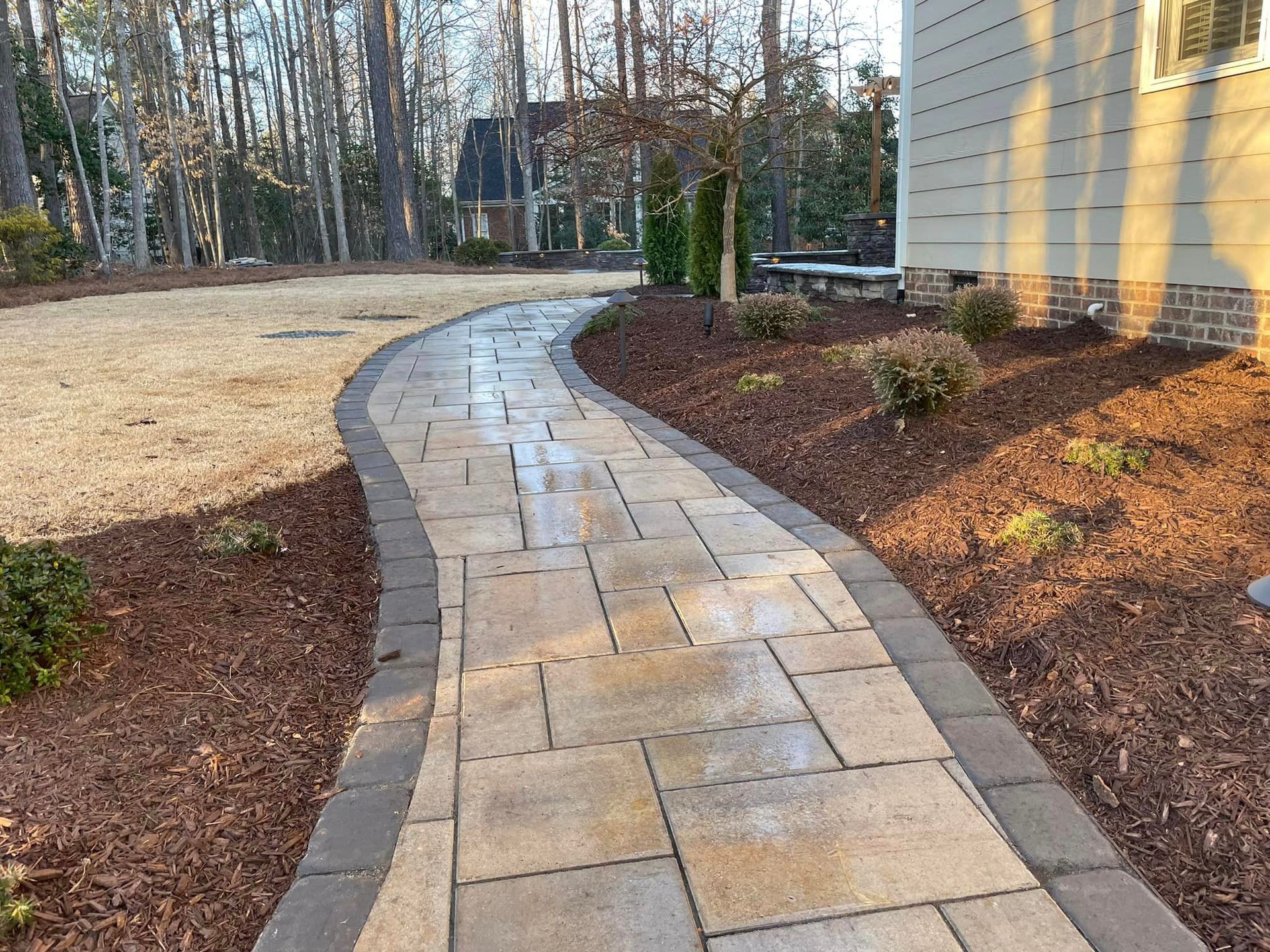 A brick walkway leading to a house in the woods