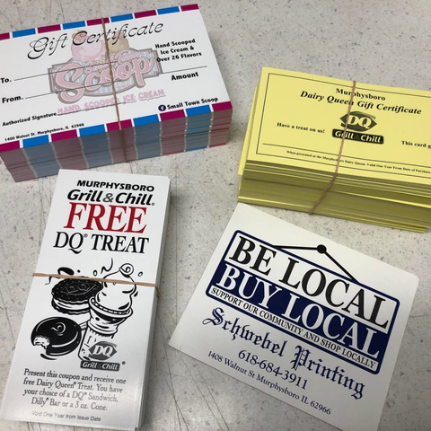 Assorted DQ gift certificates and coupons stacked on a white surface, including “Grill & Chill FREE DQ Treat” cards.