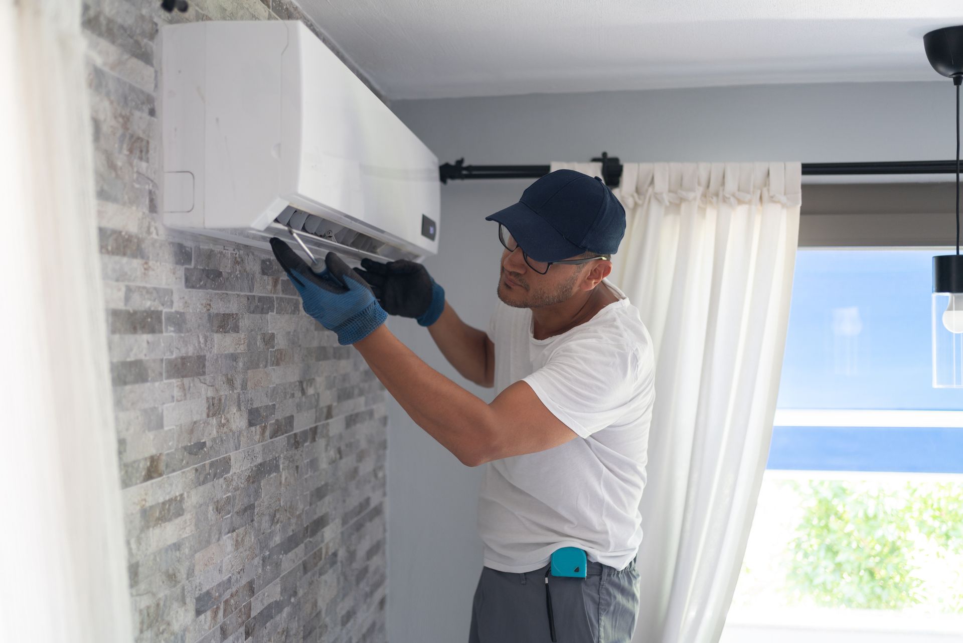 Installing an air conditioner unit indoors.