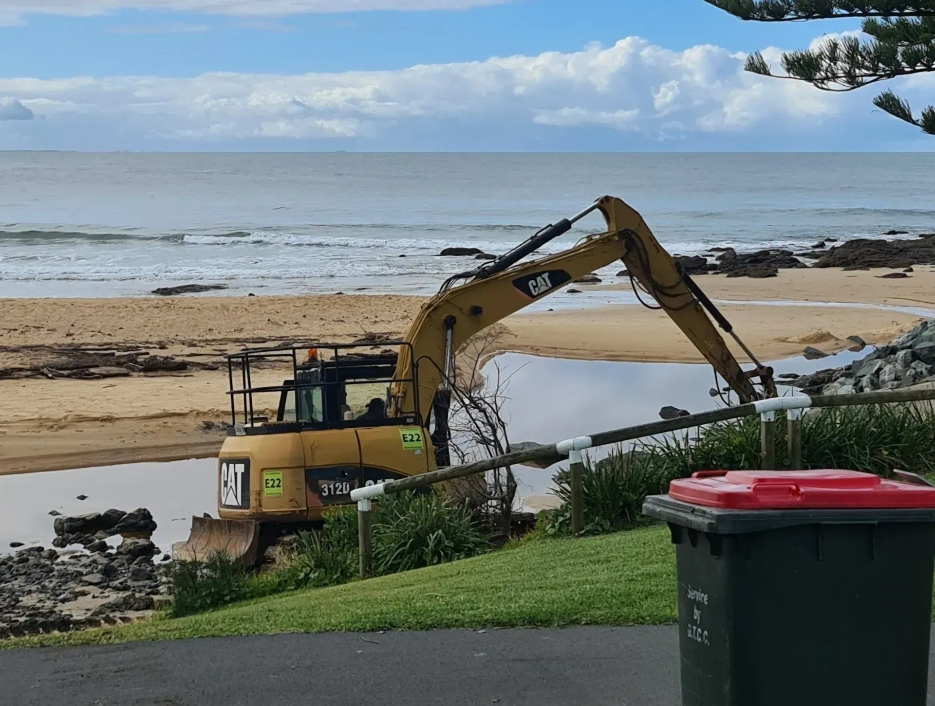 Yellow Excavator Working on A Sandy Beach Near the Ocean — Jim Anderson Earthmoving Pty Ltd in Coopernook, NSW
