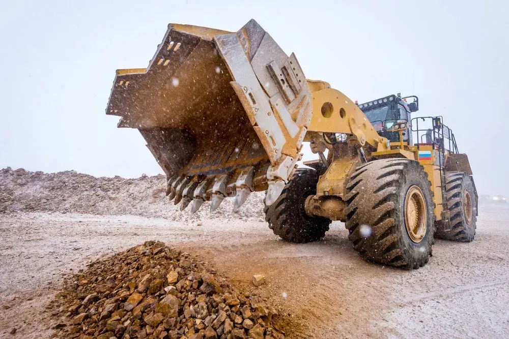 Large Yellow Earthmover Dumping Soil on a Snowy Day — Jim Anderson Earthmoving Pty Ltd In Taree, NSW