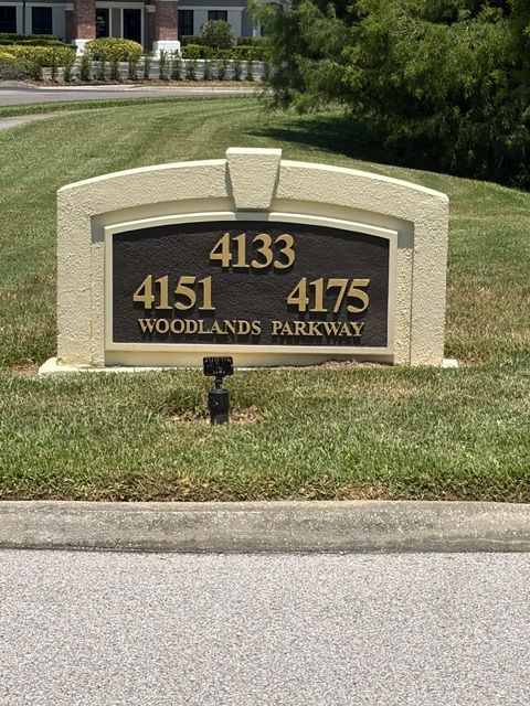 Woodland Parkways entrance sign with addresses 4133, 4151, and 4175 on a landscaped lawn.