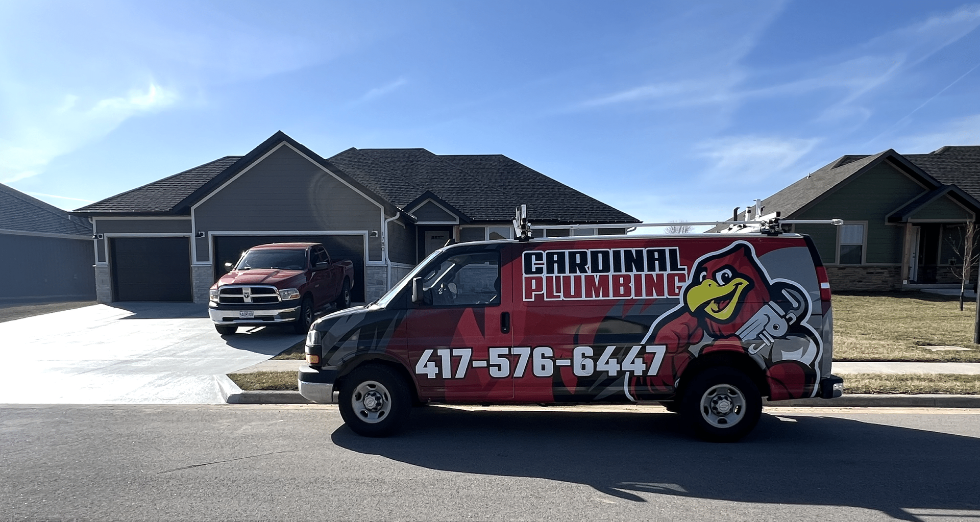 Cardinal Plumbing work van parked in front of a suburban house on a sunny day.