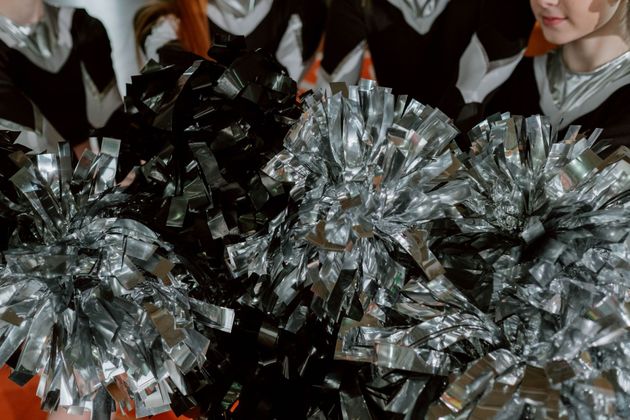 Red, white, and blue pom-poms held high by cheerleaders during a performance.