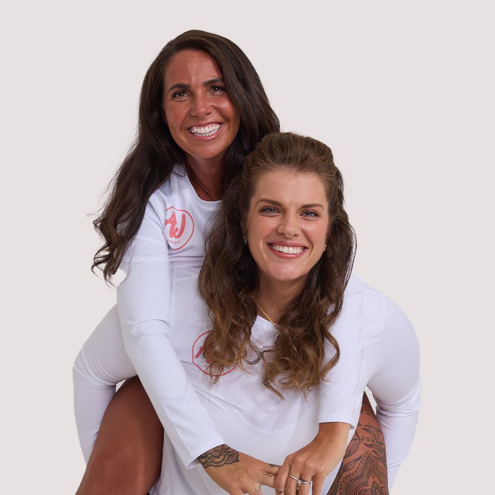 Two women wearing white shirts are posing for a picture -  - Average Jenn's - Personalized Workout and Nutrition Plans