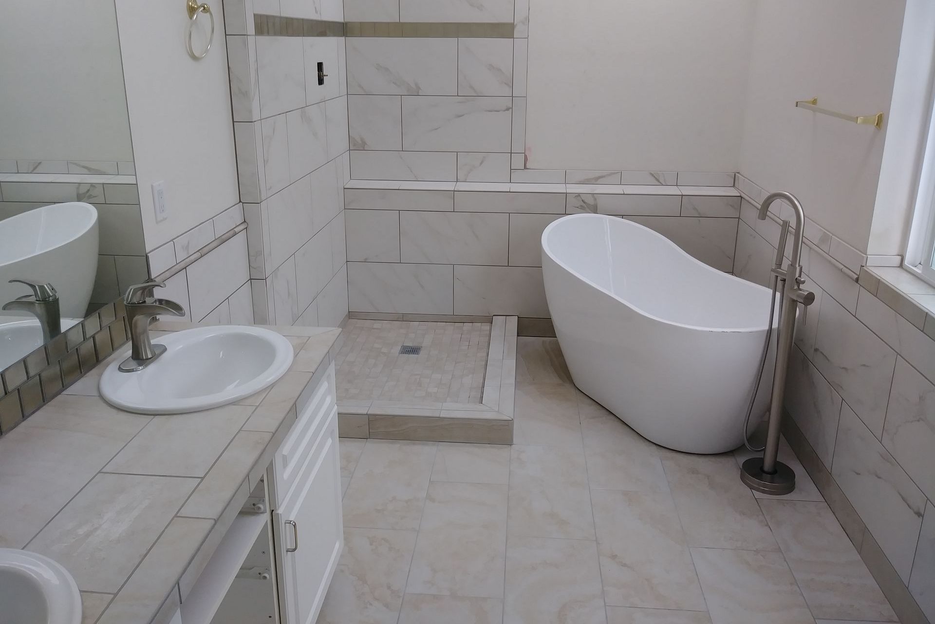 A bathroom with a tub , sink , and shower.