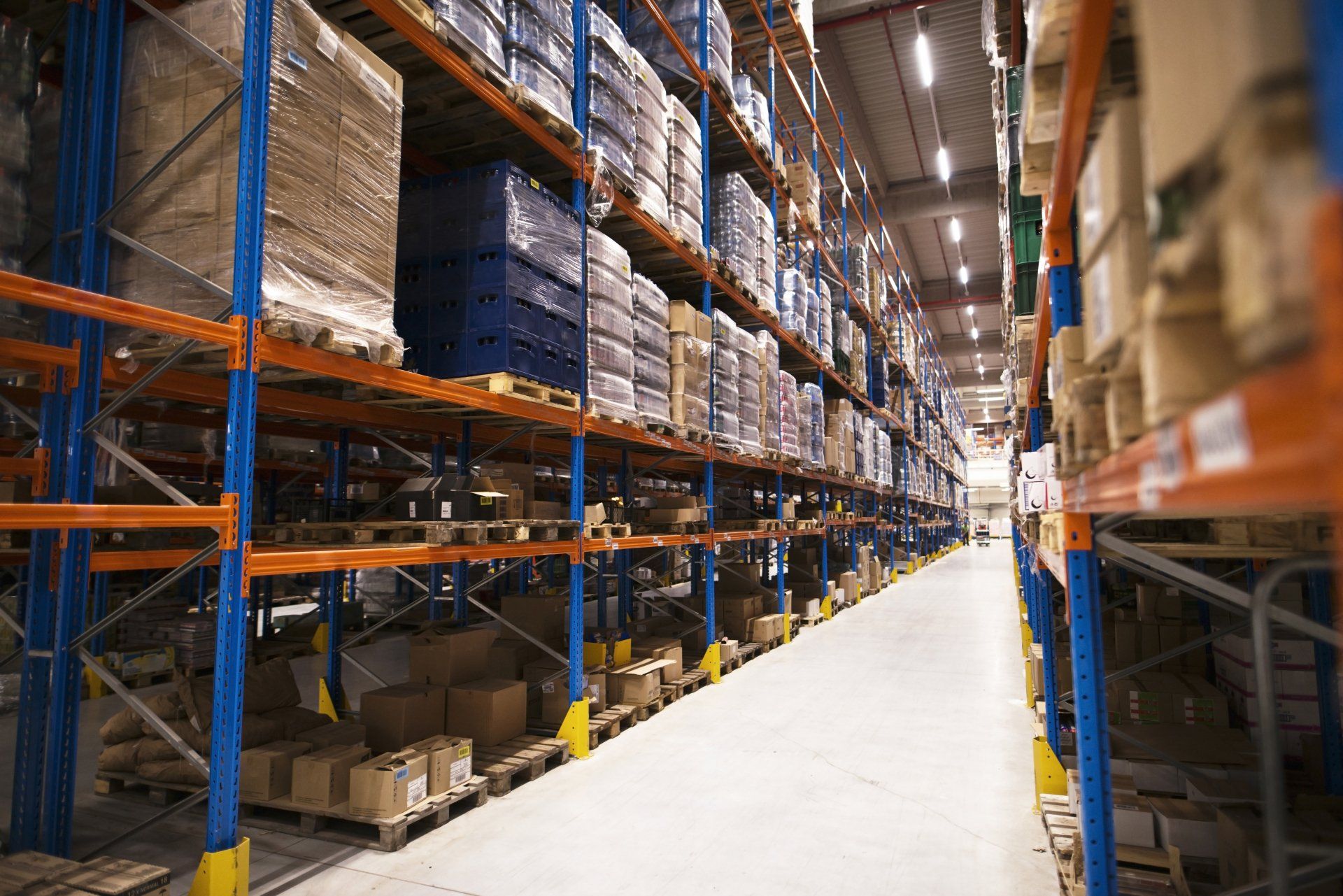 Interior del gran almacén de distribución con estantes apilados con paletas y productos listos para el mercado Interior del gran almacén de distribución con estantes apilados con paletas y productos listos para el mercado
