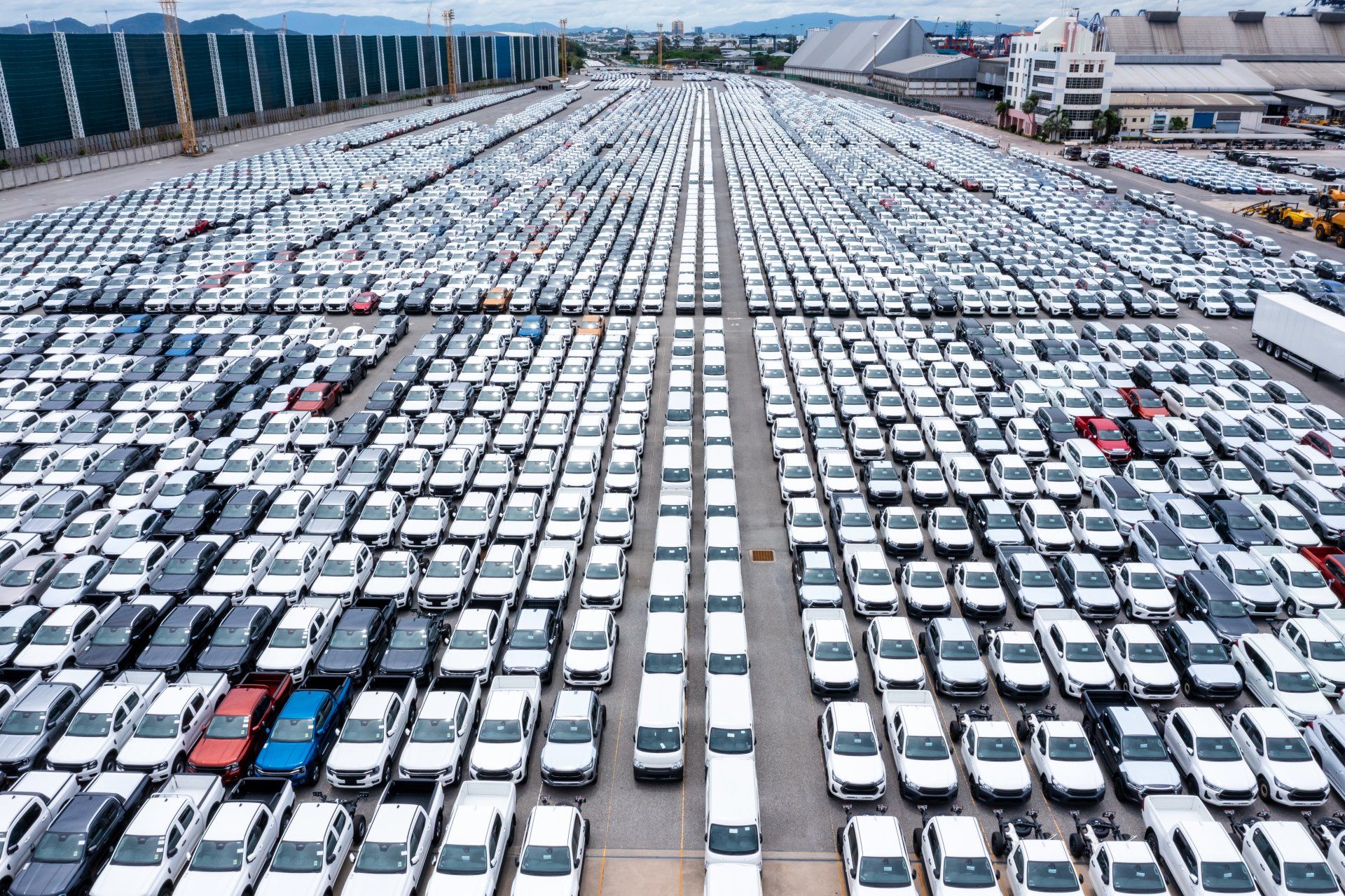 Filas de autos nuevos estacionados en el almacén de la fábrica para distribuidores que comercian Filas de autos nuevos estacionados en el almacén de la fábrica para distribuidores que comercian