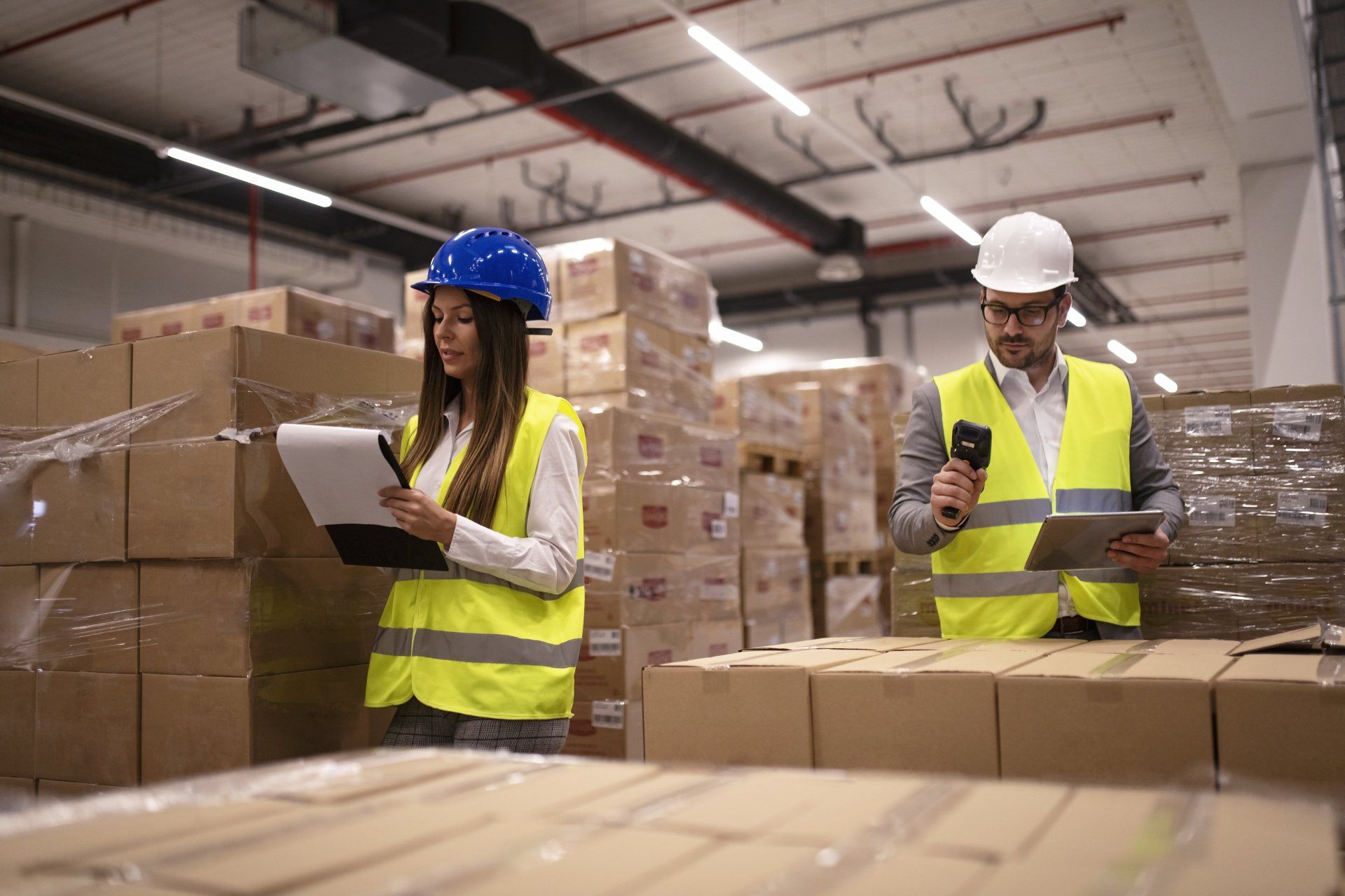 Trabajadores del almacén con escáner de código de barras y tableta en control del inventario de mercancías Trabajadores del almacén con escáner de código de barras y tableta en control del inventario de mercancías