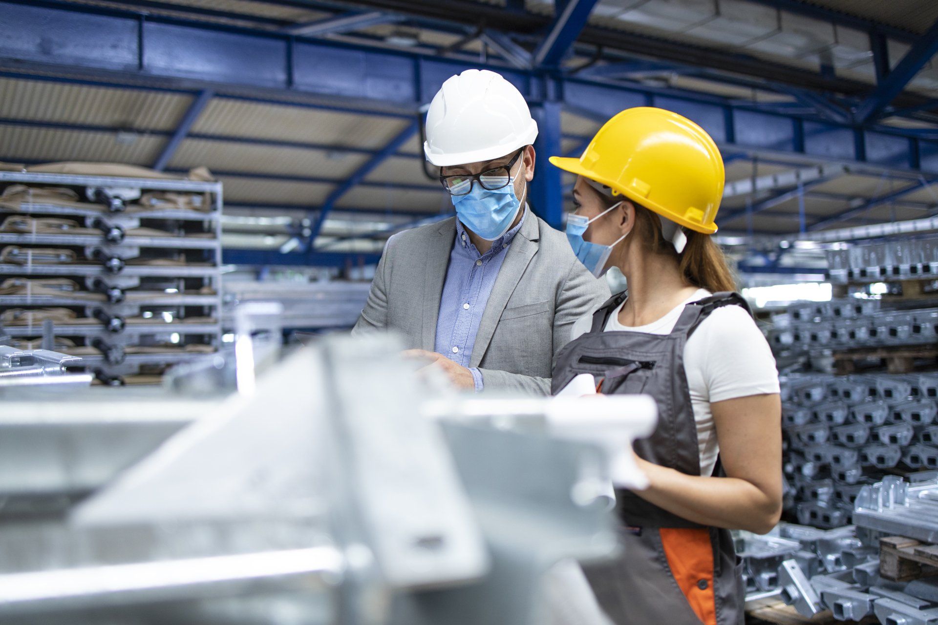 Gerente de supervisor industrial con máscara higiénica hablando con trabajadora en la línea de producción Gerente de supervisor industrial con máscara higiénica hablando con trabajadora en la línea de producción