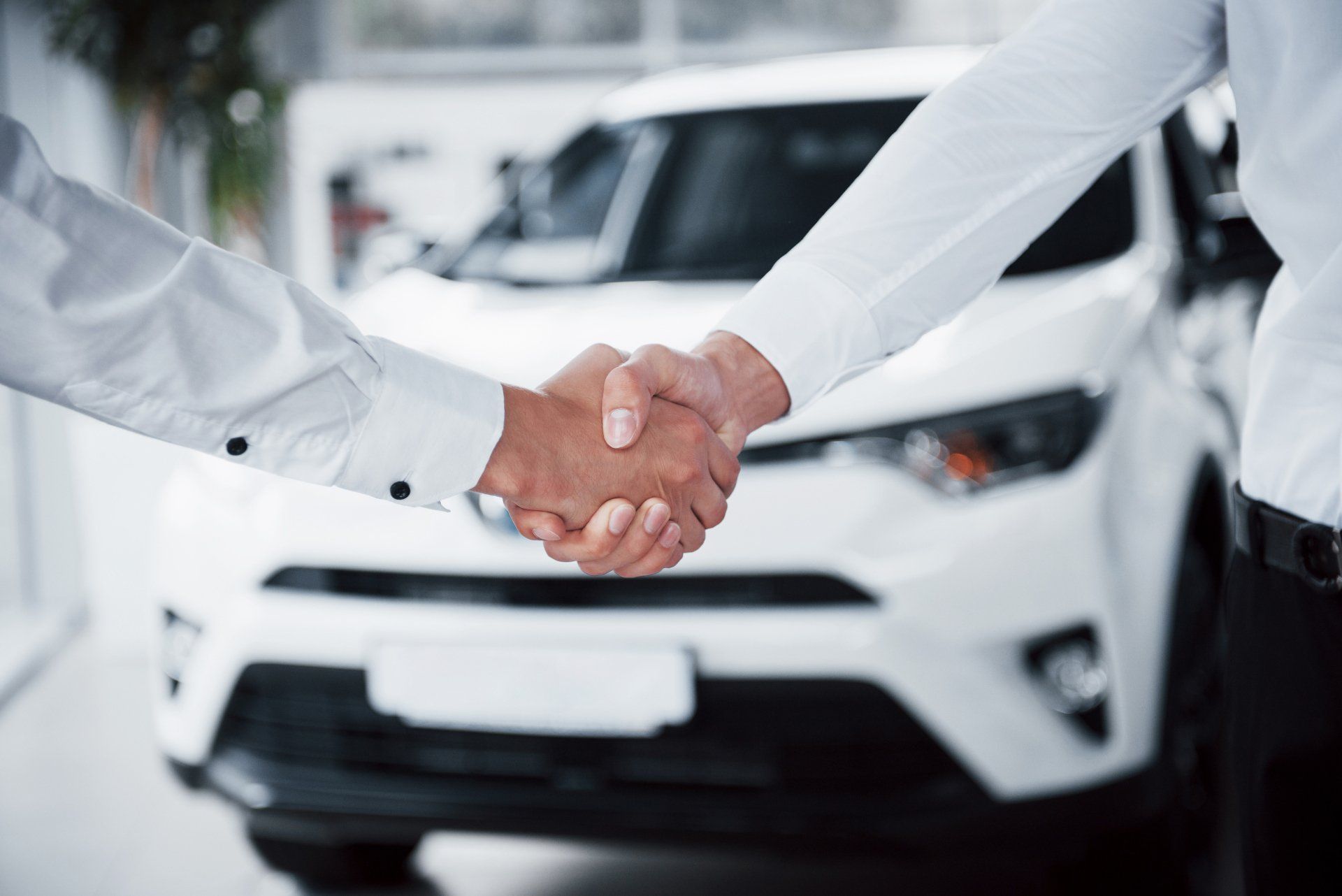 Cierre de gerente de ventas en traje negro vendiendo el auto al cliente Cierre de gerente de ventas en traje negro vendiendo el auto al cliente
