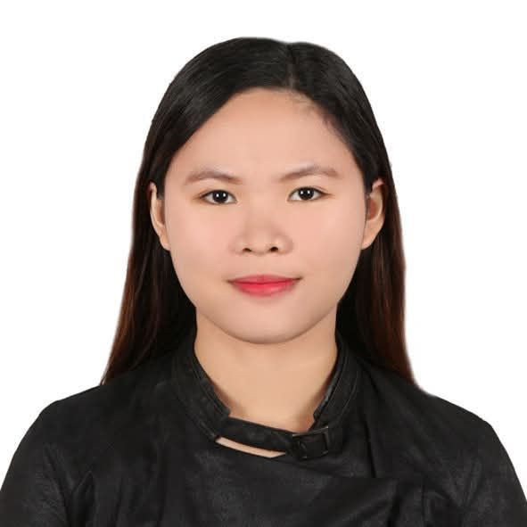 Studio headshot of a woman with long black hair, wearing a black top, against a white background