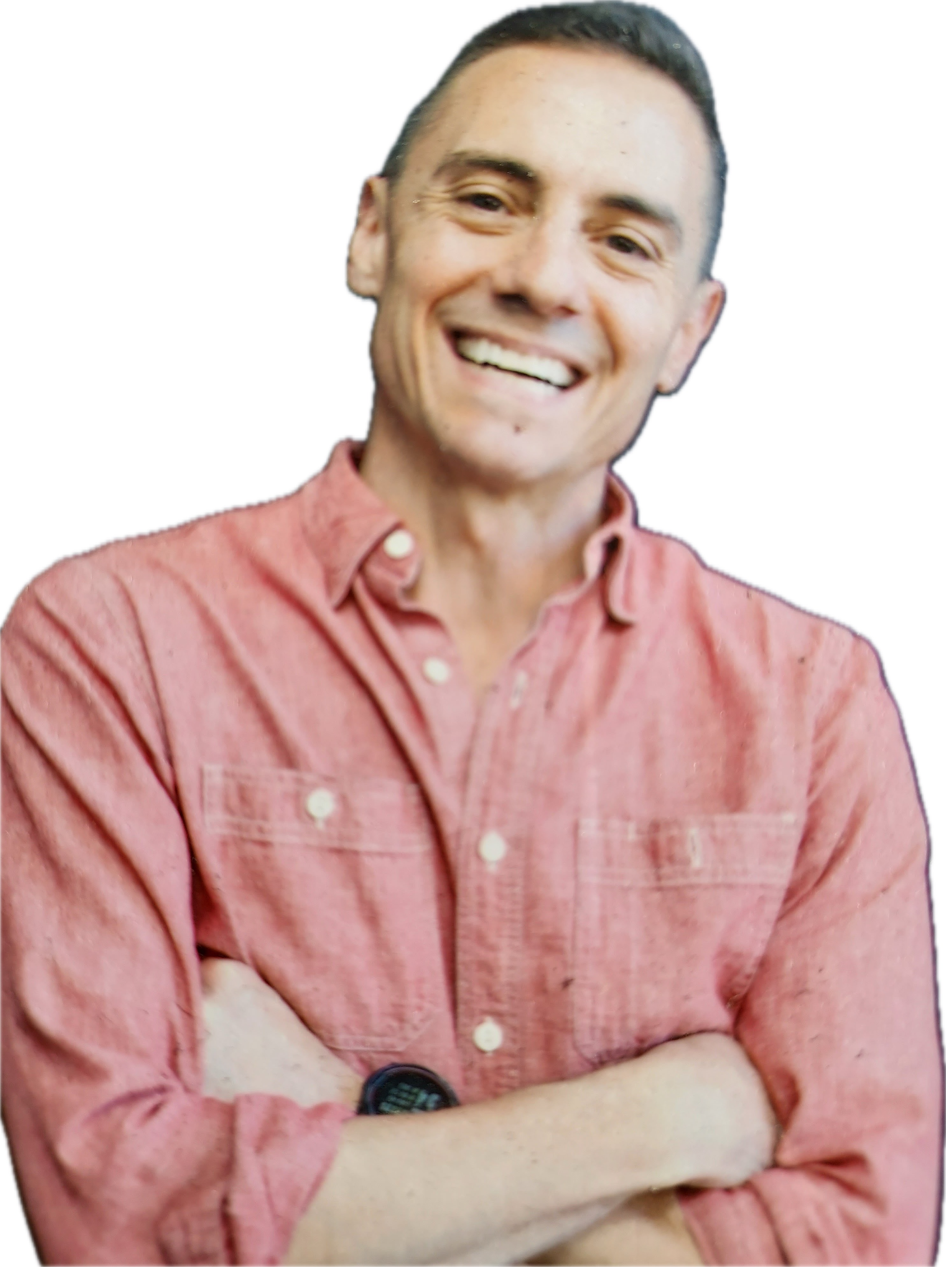 Smiling person in a pink button-up shirt with arms crossed against a white background