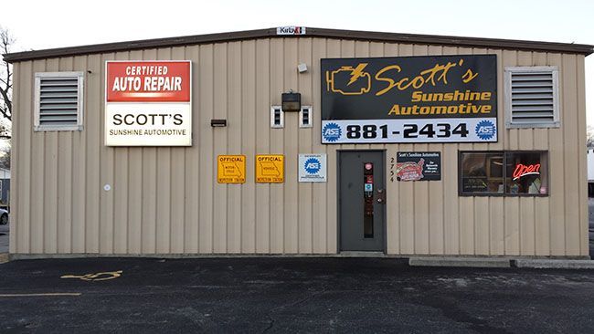 Scott's Sunshine Automotive building, tan exterior, signs, door, windows, parking area.