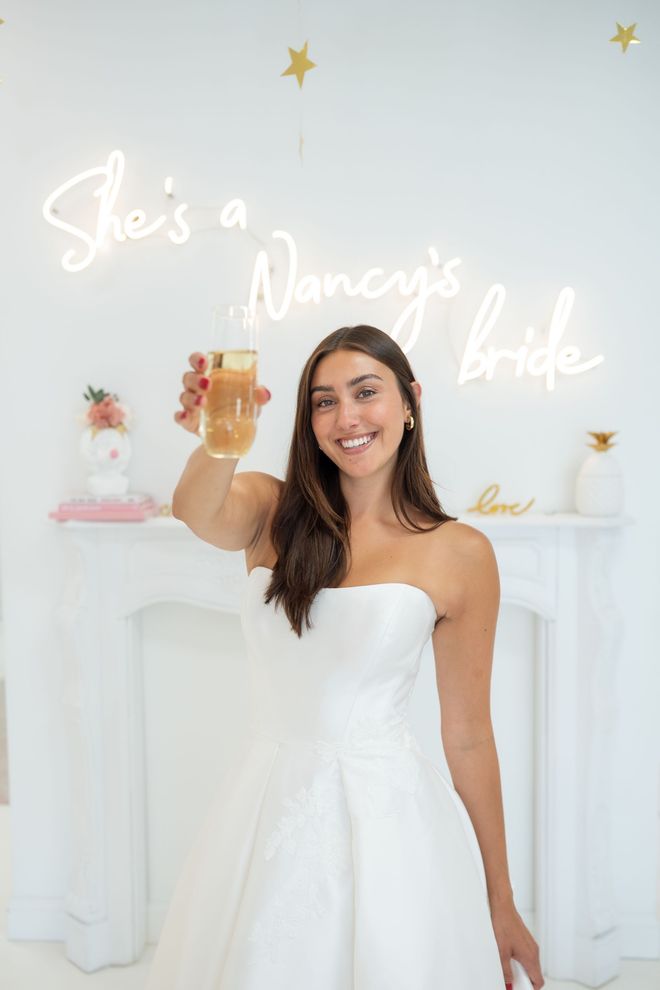 Woman in wedding dress toasting with champagne,