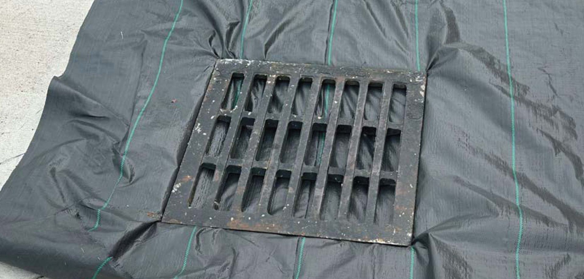 Close-up of a gray fabric surface with a rectangular black vent or grate opening.