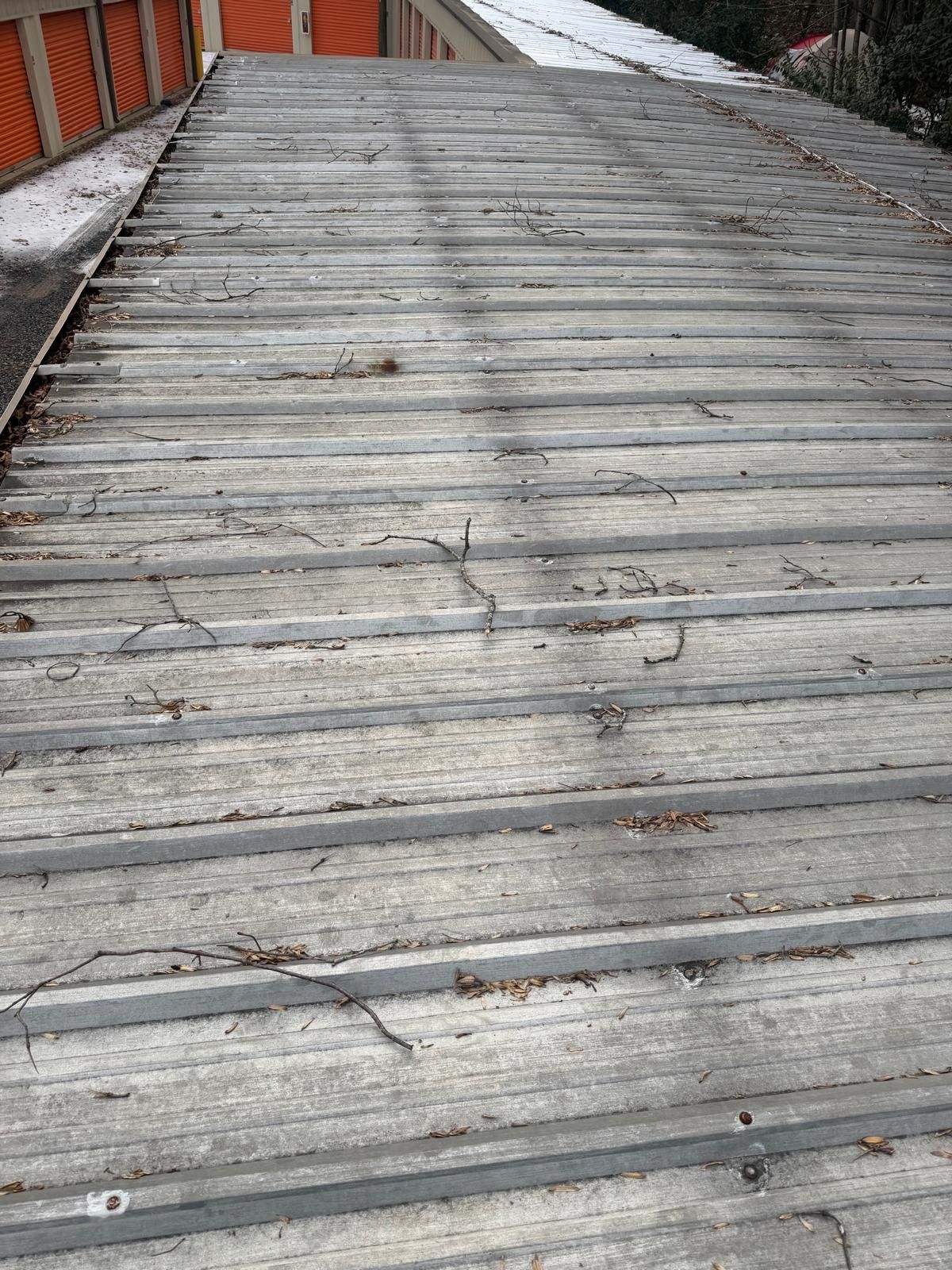 Weathered wooden walkway with peeling gray boards and metal railing alongside brick walls