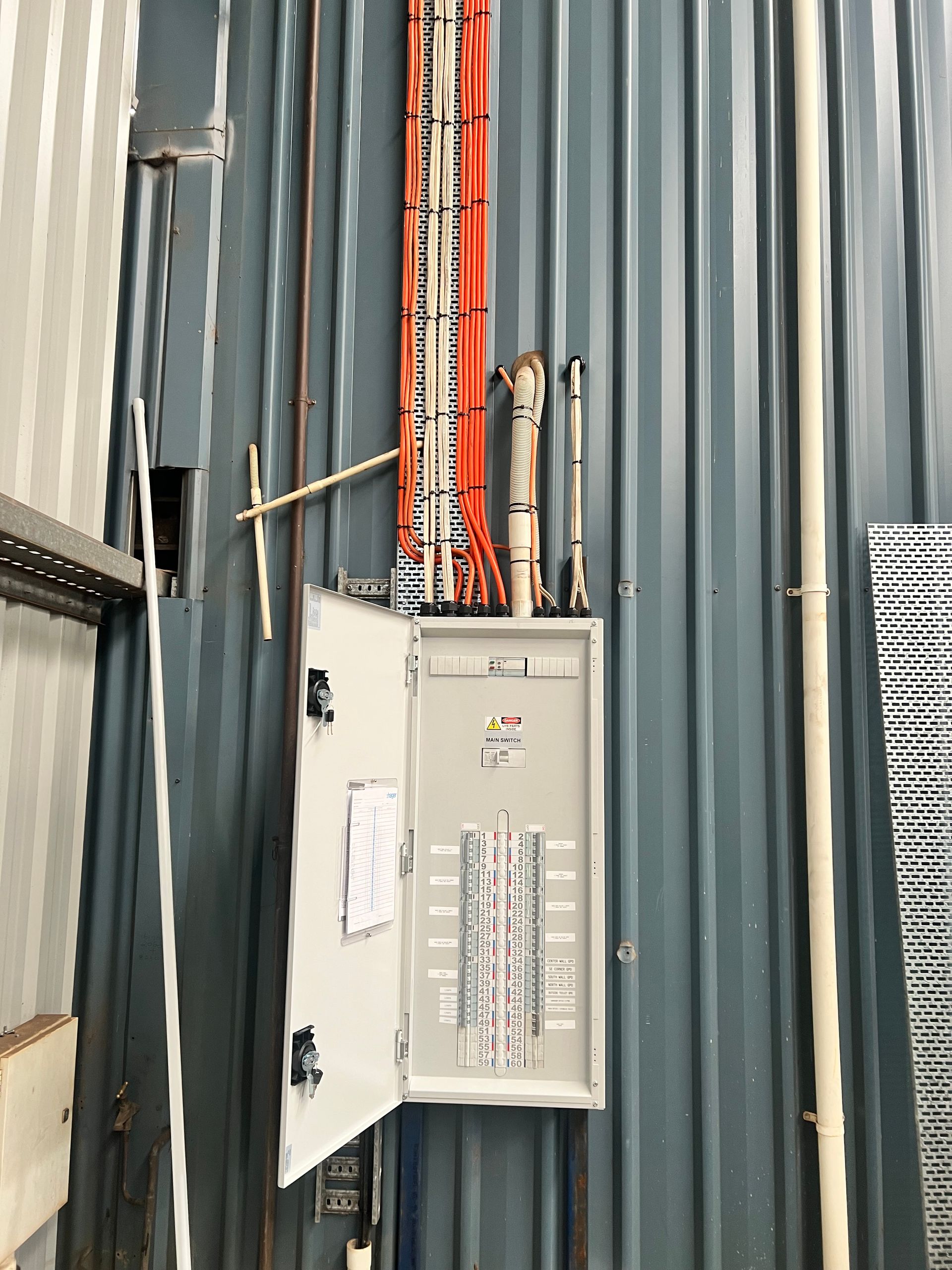 A Man is Using a Digital Multimeter to Test an Electrical Box — Himec Electrical In Withcott, QLD