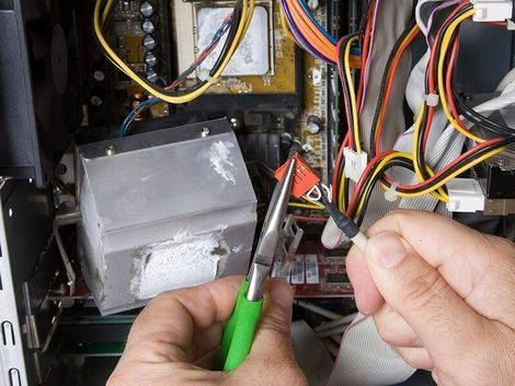 A Person is Working on a Computer With a Pair of Pliers — Himec Electrical In Withcott, QLD