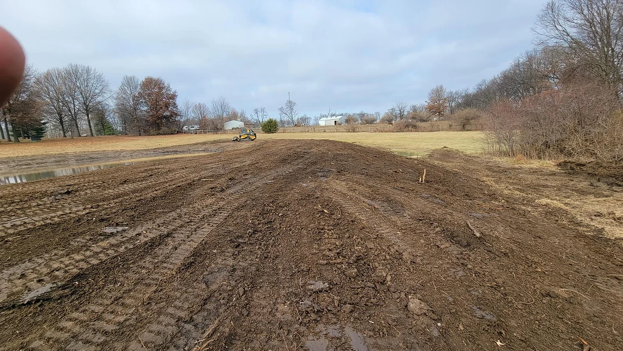 An image of a muddy field with a bulldozer.