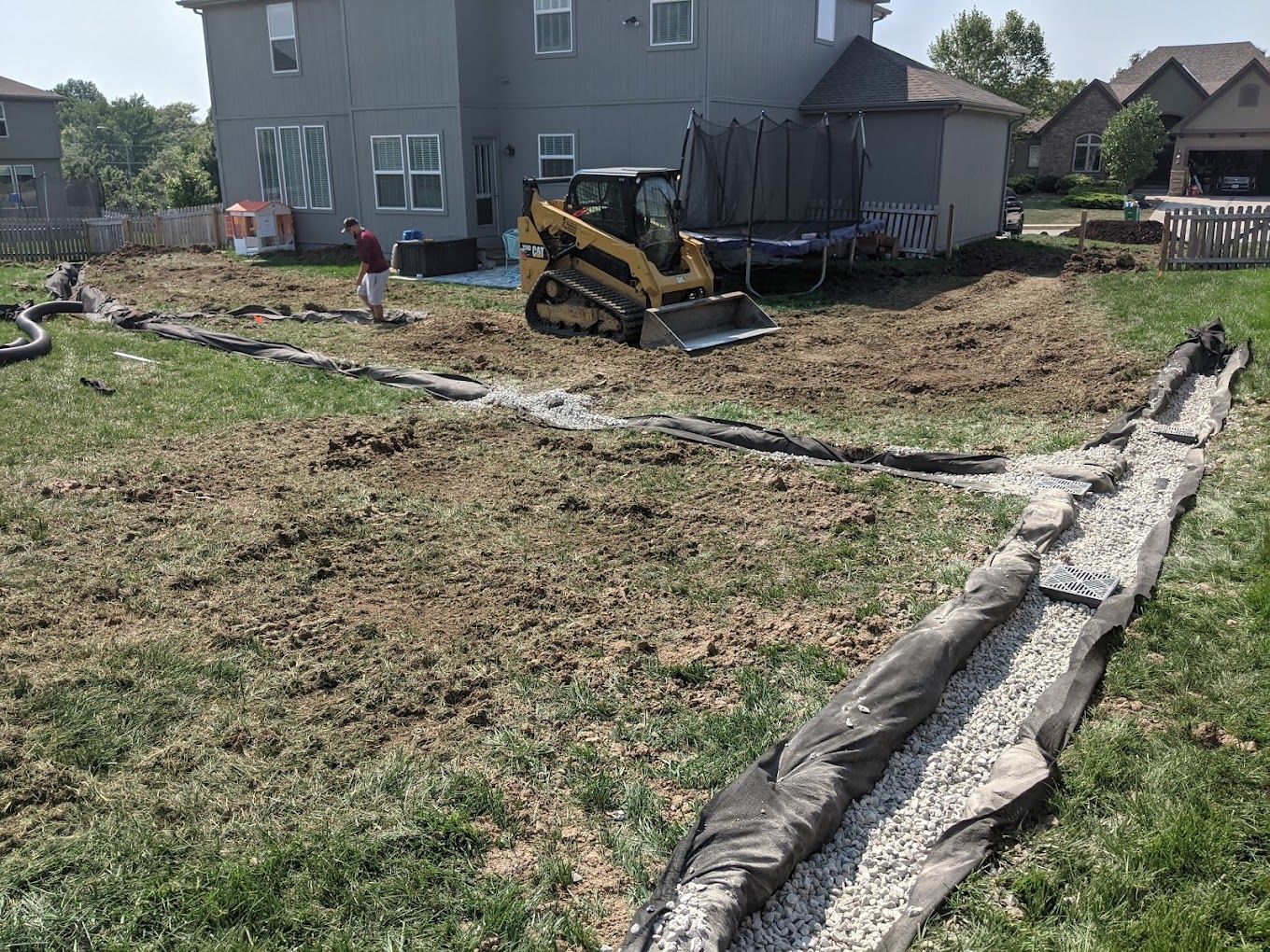 A bulldozer is sitting in the dirt in front of a house.