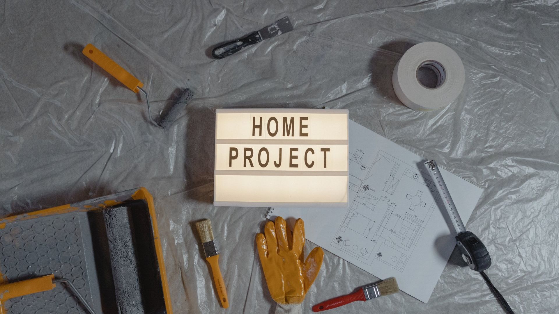 A sign that says `` home project '' is surrounded by tools on a table.