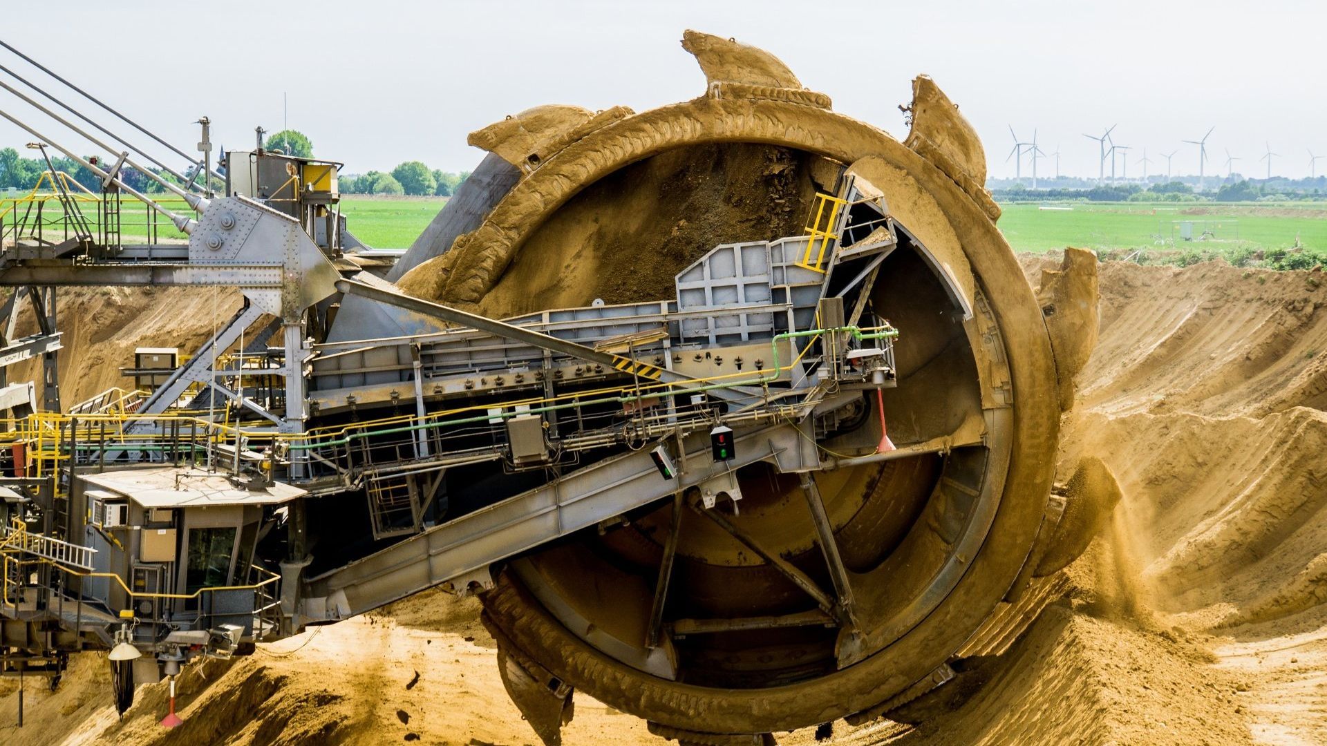 A large excavator is digging a hole in a dirt field.