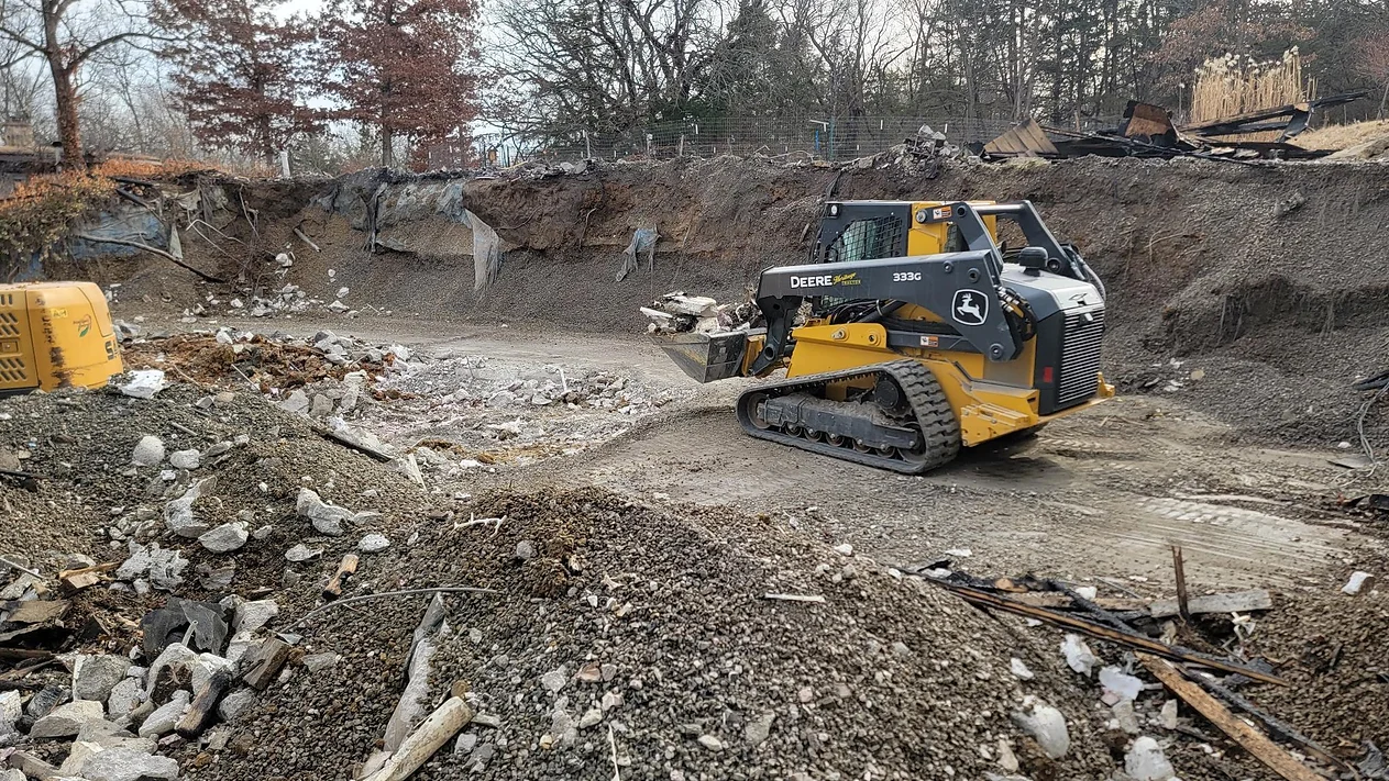 A bulldozer is driving through a pile of rocks.