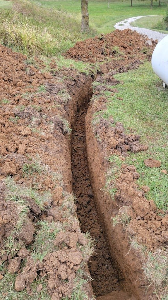 A trench is being dug in the grass in a yard.