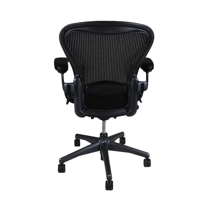 Used Herman Miller Aeron Black ergonomic office chair, back view, with a mesh back and adjustable arms.