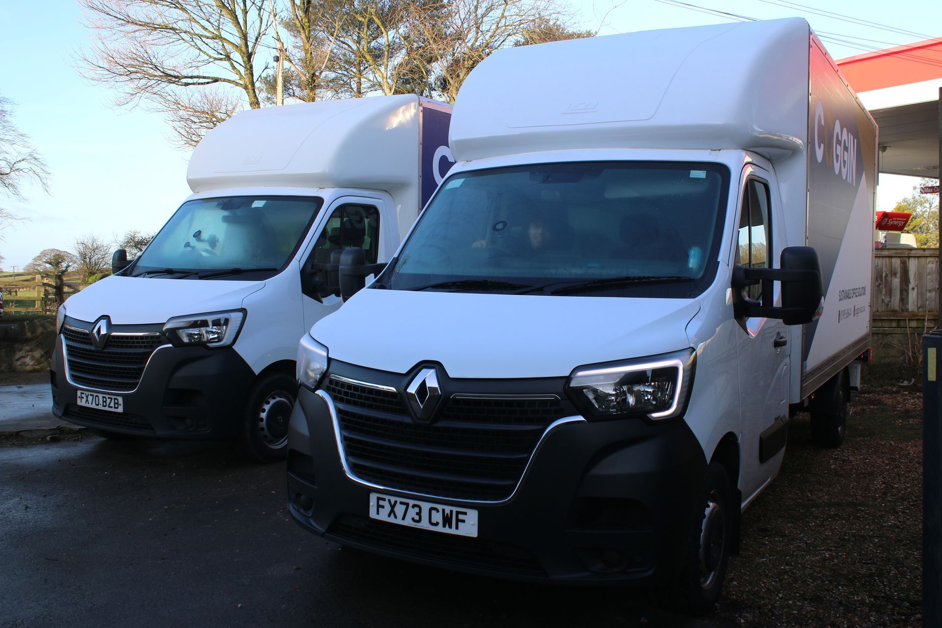 Two white Renault Master vans parked outside.