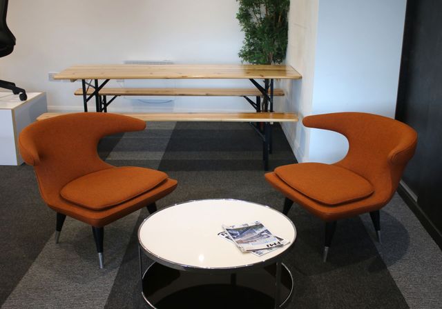 Refurbished orange tub chairs and coffee table in an office breakout area