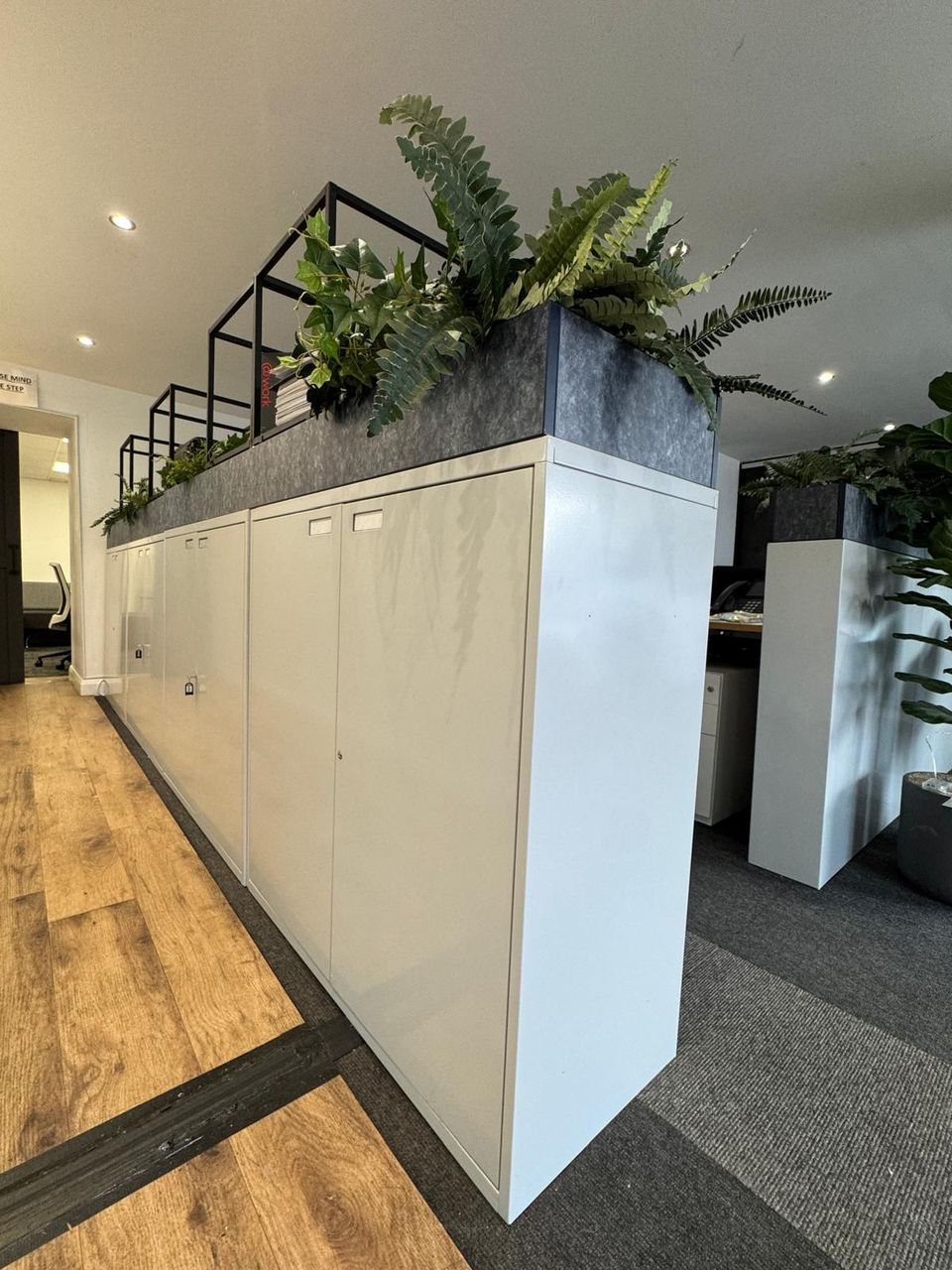 Run of refurbished white office cupboards forming a room divider