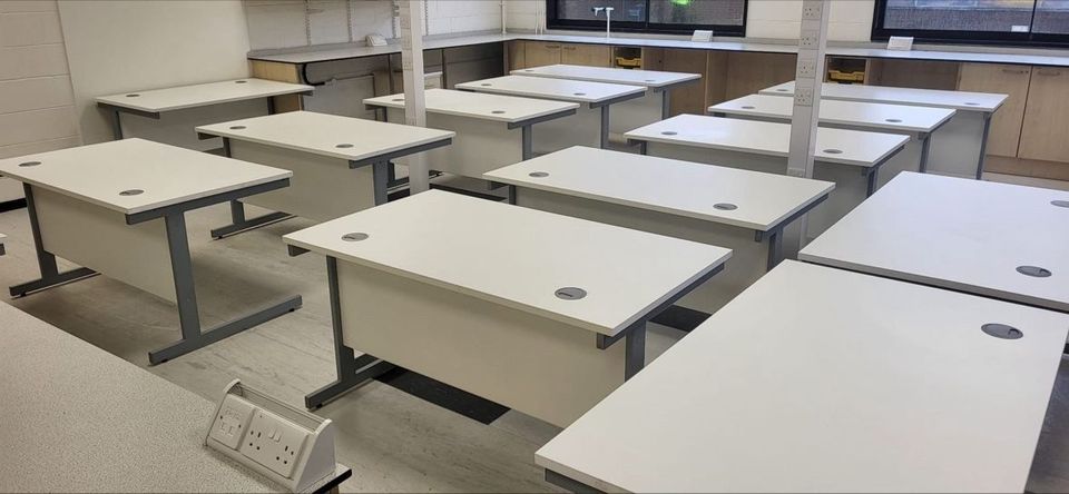 Refurbished desks delivered and positioned in a room, ready for use