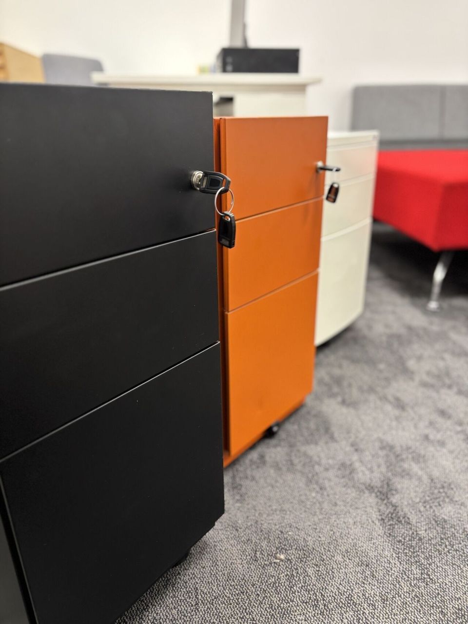 Refurbished black orange and white pedestals in a row with keys in the locks