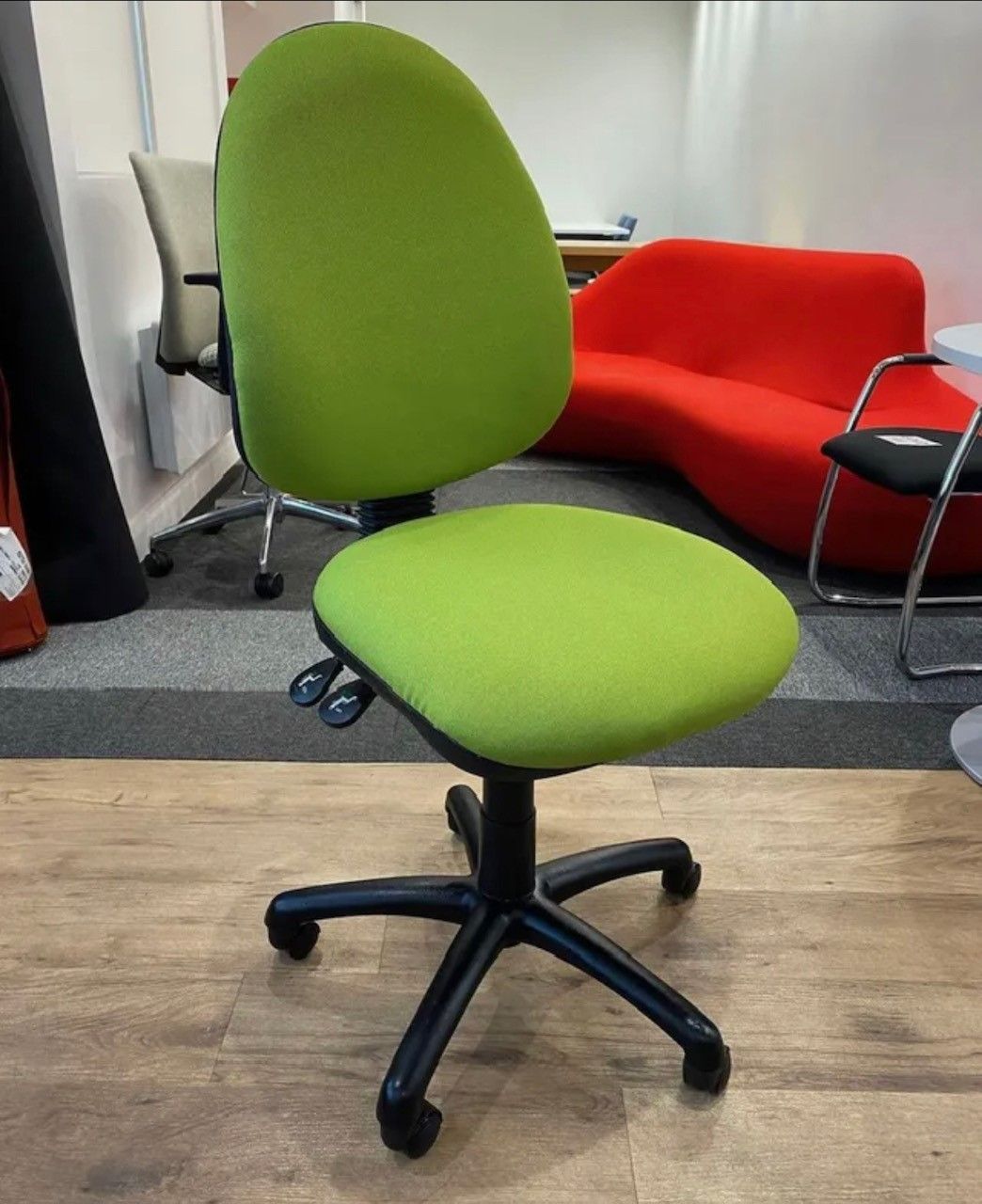 Green office chair on a black base, with a green backrest and seat.
