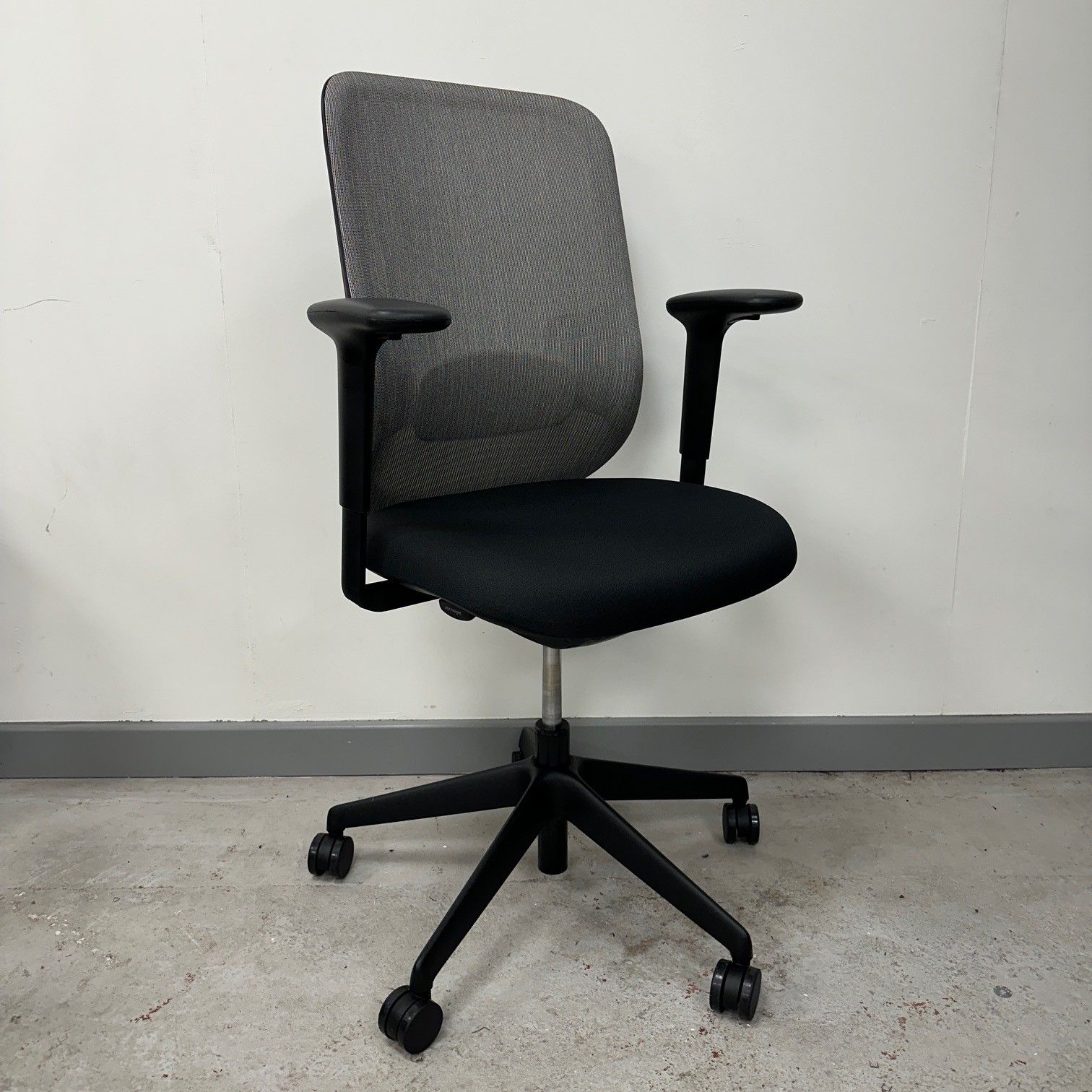 Office chair with gray mesh back, black seat and arms, and black wheeled base.