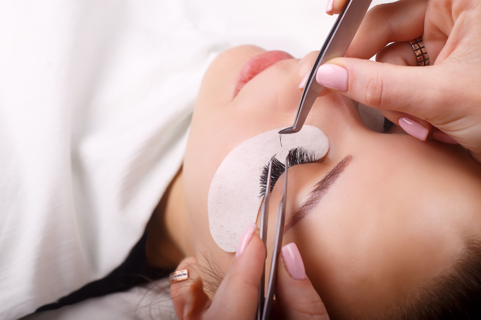 A woman is getting her eyelashes done at a beauty salon.