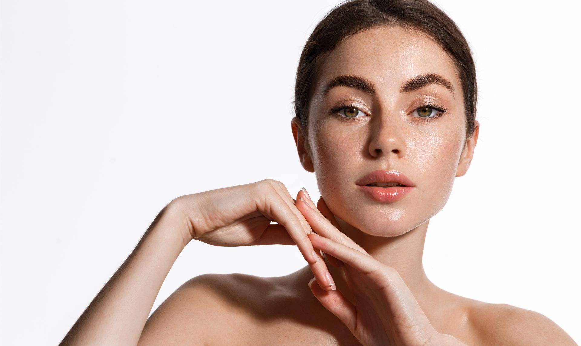 A close up of a woman 's face with her hands on her chin.