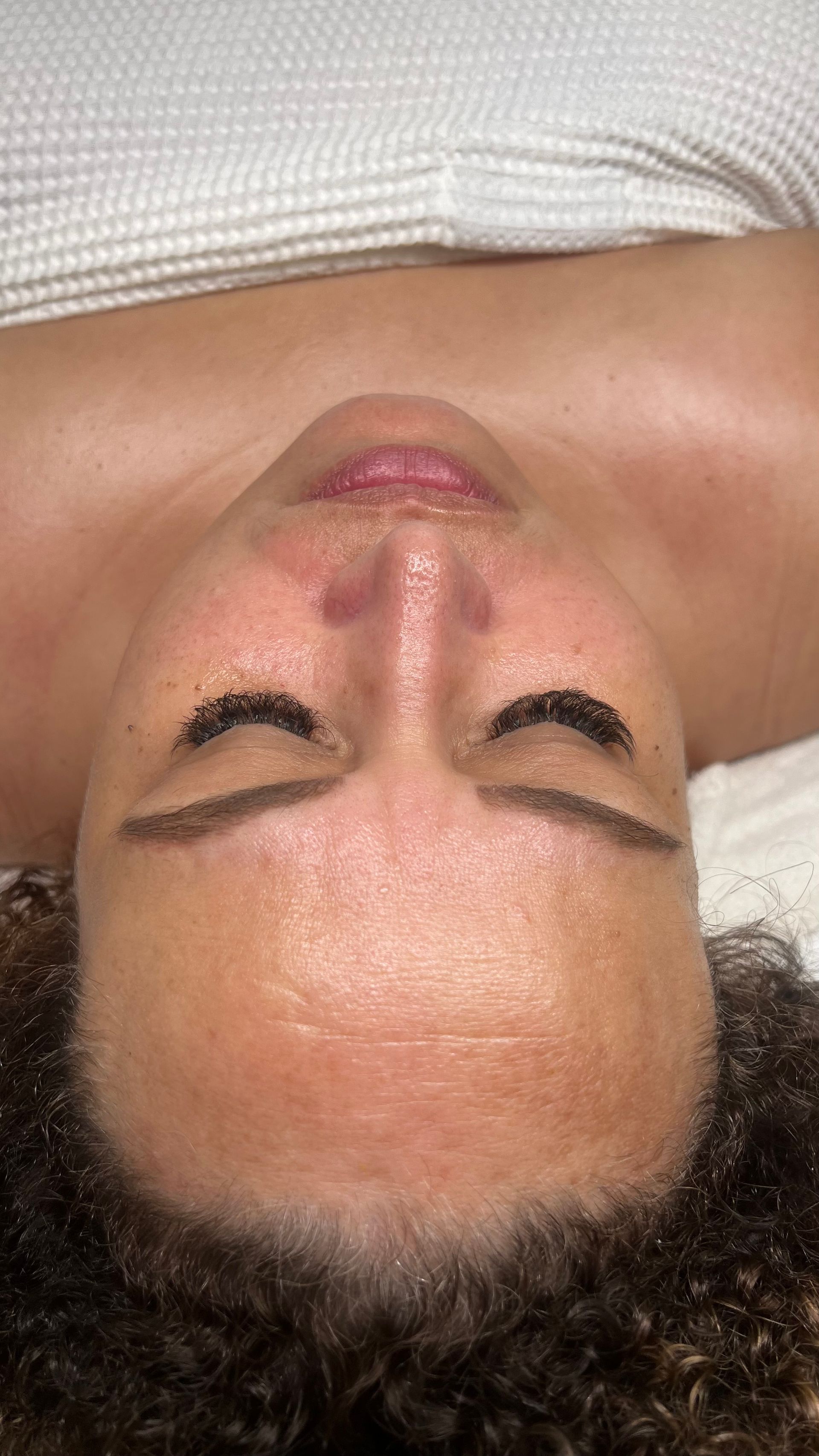 A close up of a woman 's face with her eyes closed.