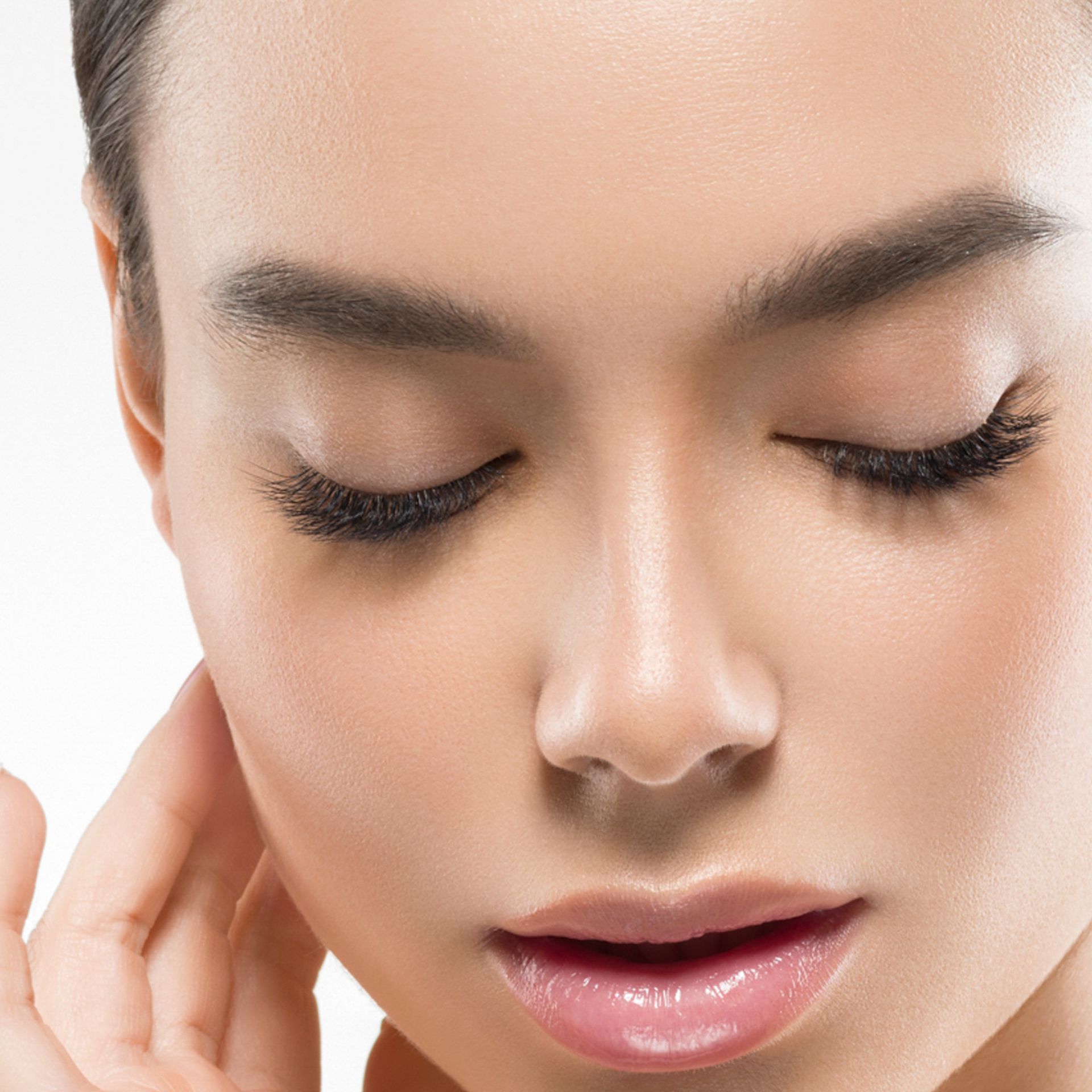 A close up of a woman 's face with her eyes closed