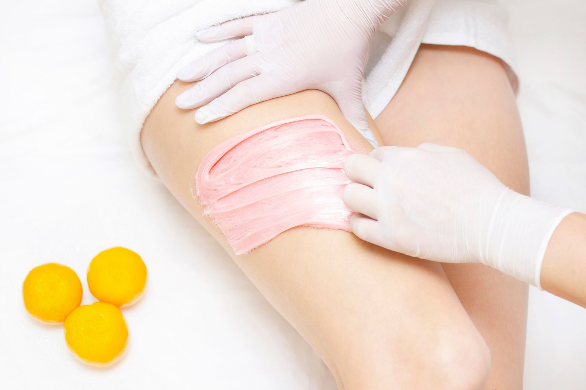 A woman is getting her legs waxed in a beauty salon.