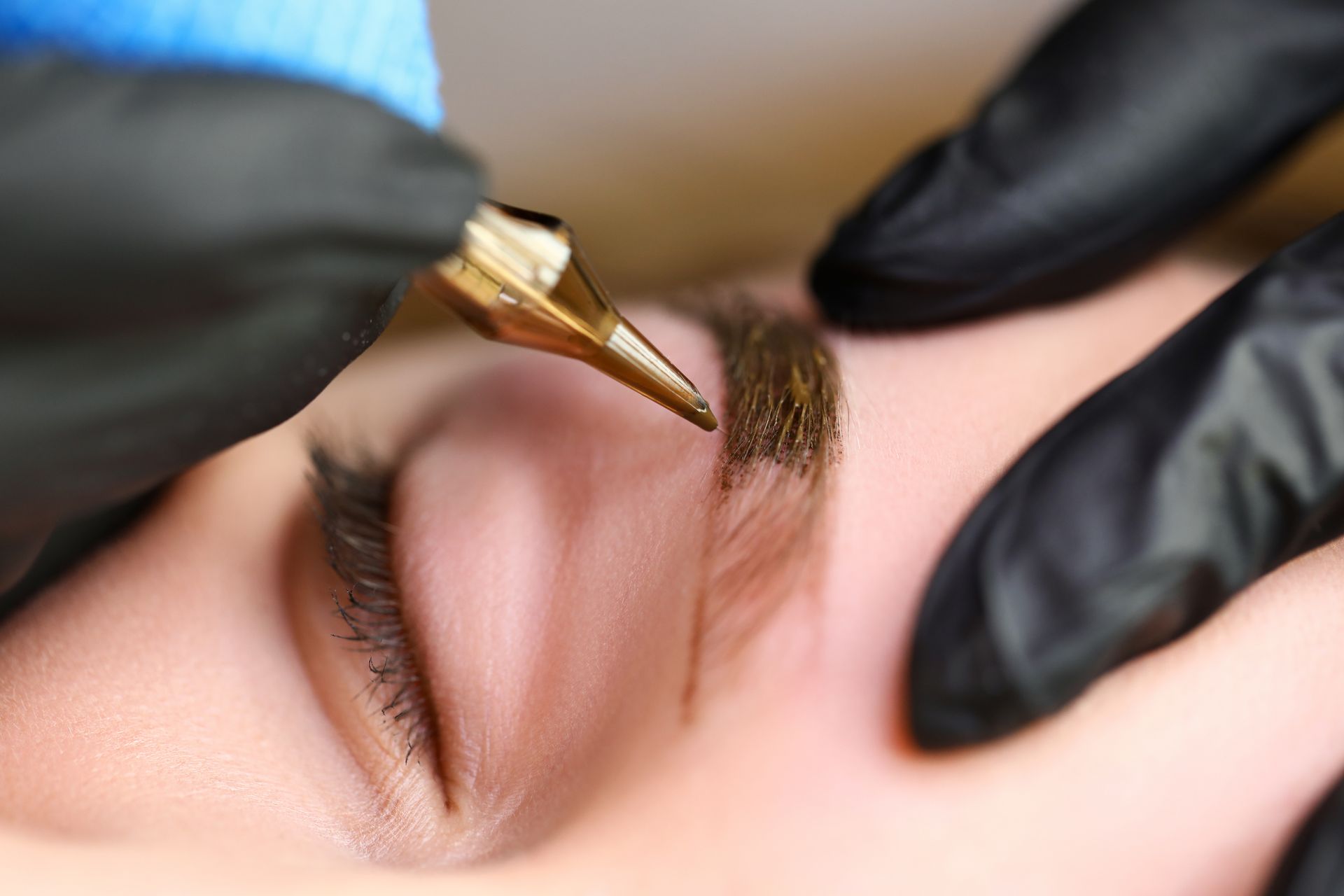 A close up of a person applying eyeliner to a woman 's eye.