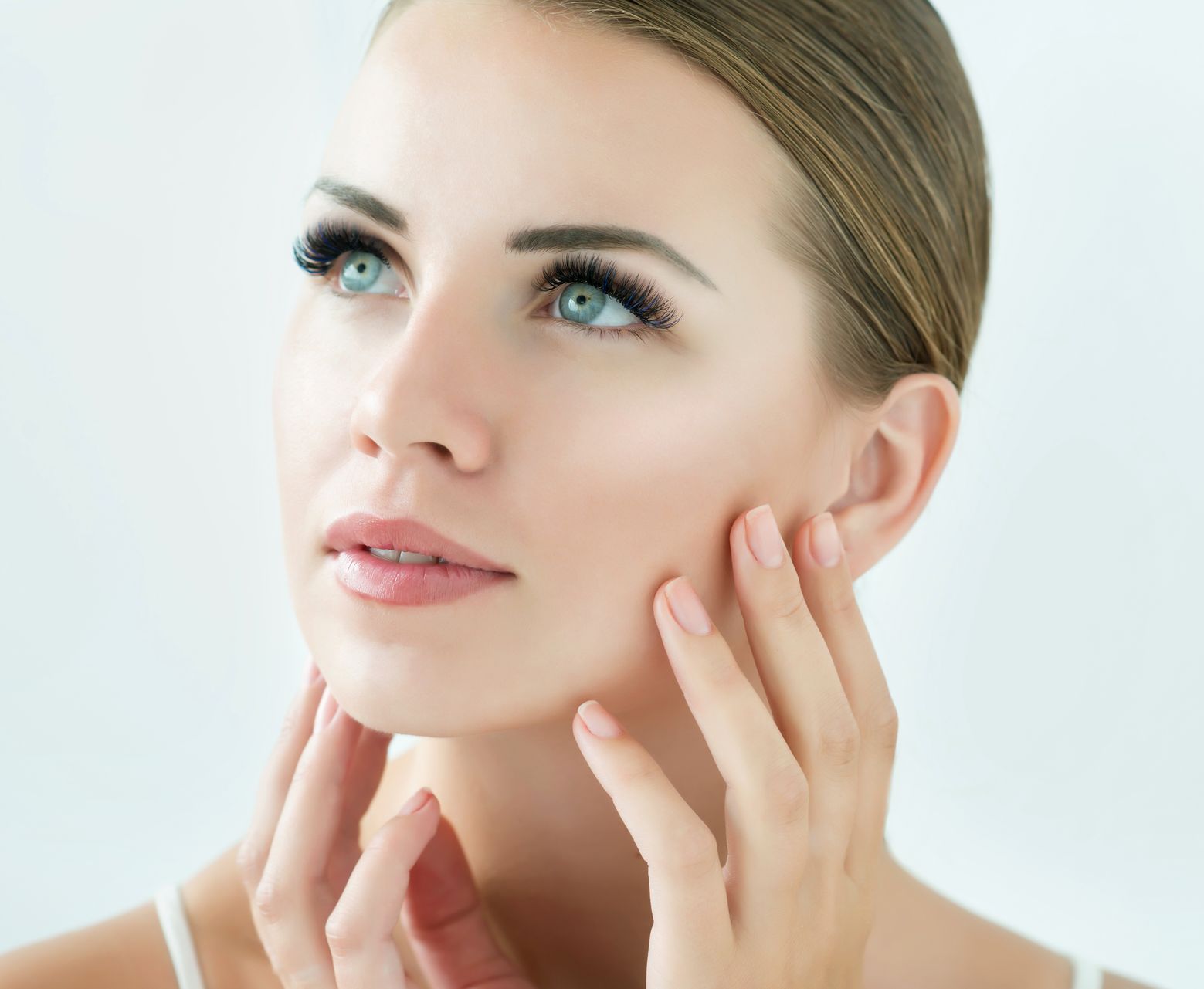 A close up of a woman 's face with her hands on it.