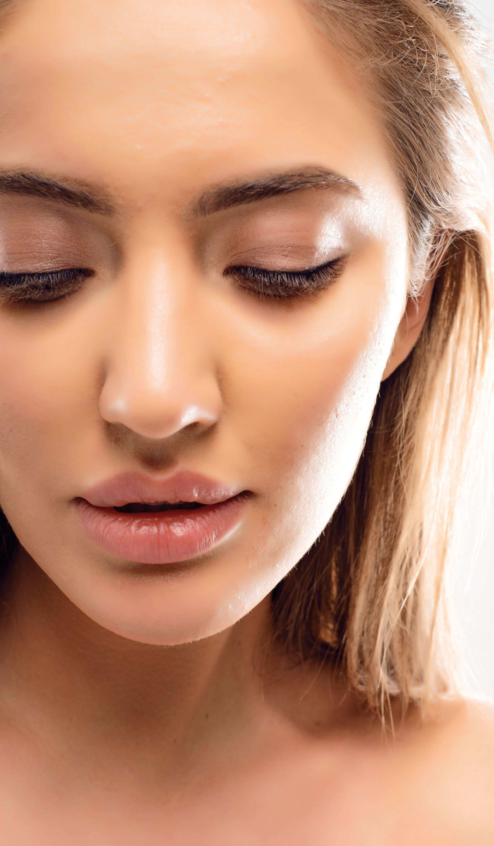 A close up of a woman 's face with her eyes closed.