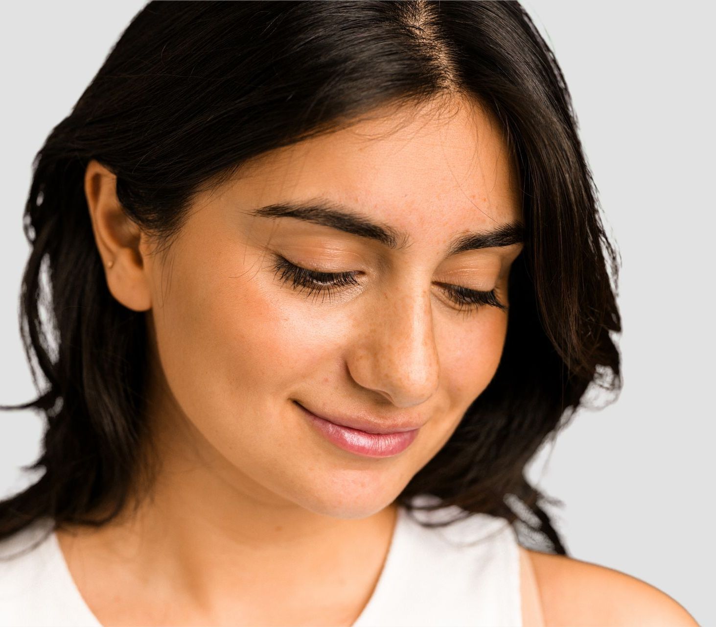 A close up of a woman 's face with her eyes closed.
