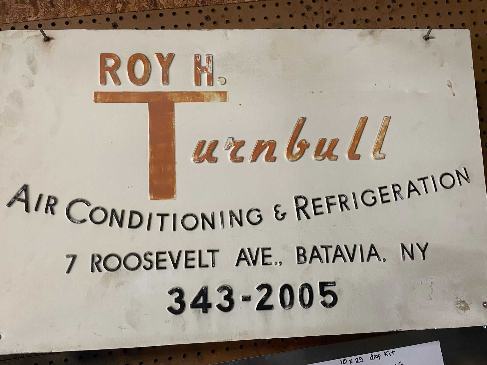 Sign for Roy H. Turnbull Air Conditioning & Refrigeration. White with orange and black lettering, located in Batavia, NY.