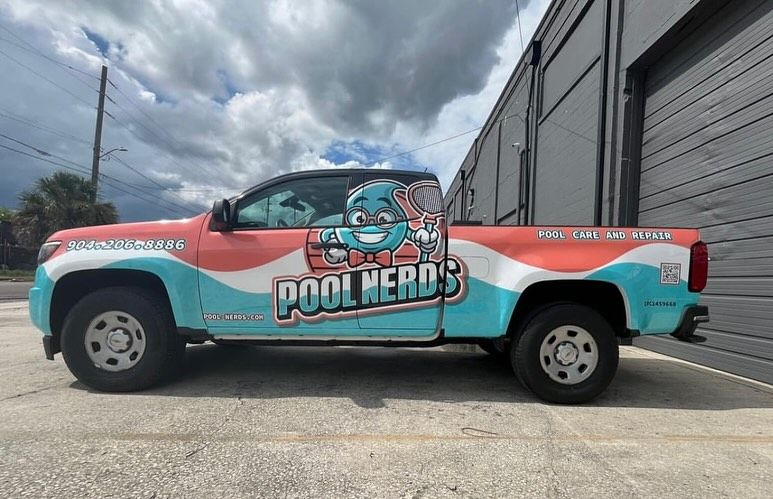 Blue swimming pool with built-in steps, set against wooden decking.