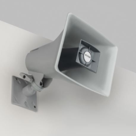 A white speaker is mounted to a wall.