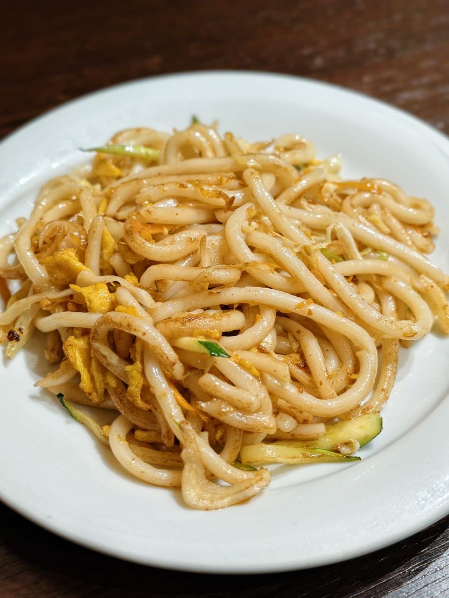 Plate of stir-fried noodles with vegetables on a white dish